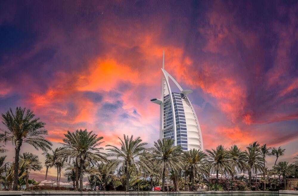 green palm trees near white building during sunset