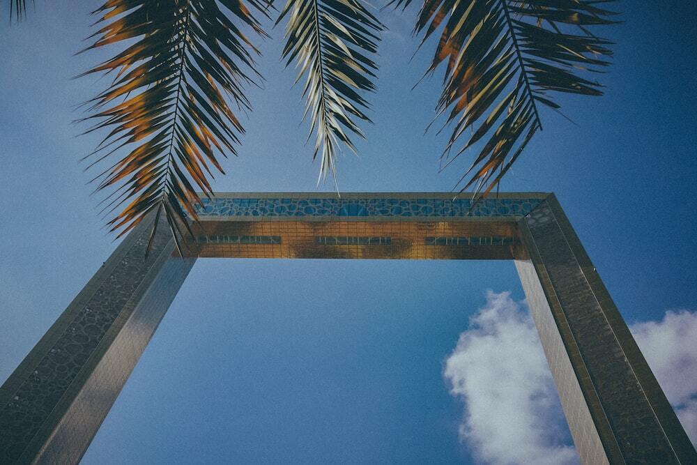 low-angle photography of gray arch near tree