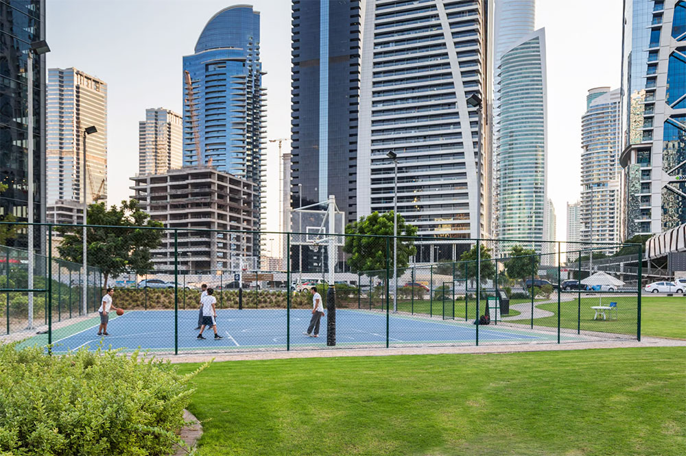 A view of a park in Jumeirah Lakes Towers with people attending a community event