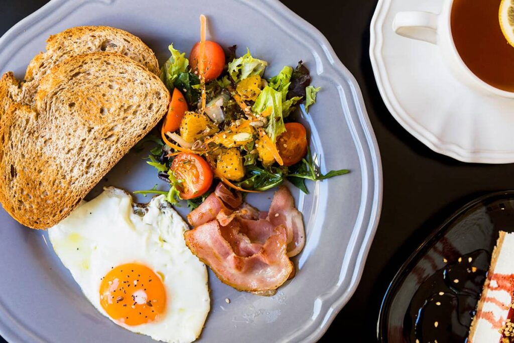 A plate of eggs benedict with gluten free dishes and fresh juices